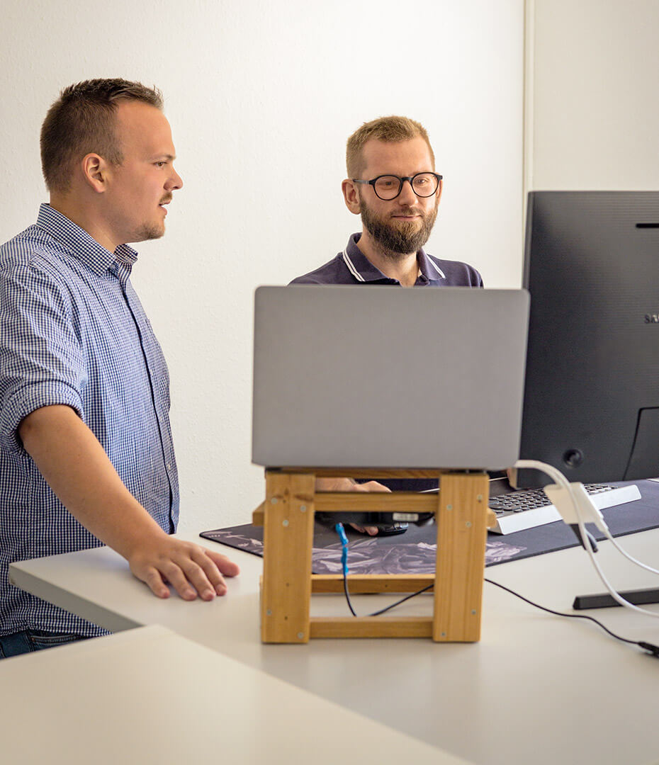Zwei Männer schauen auf Laptop